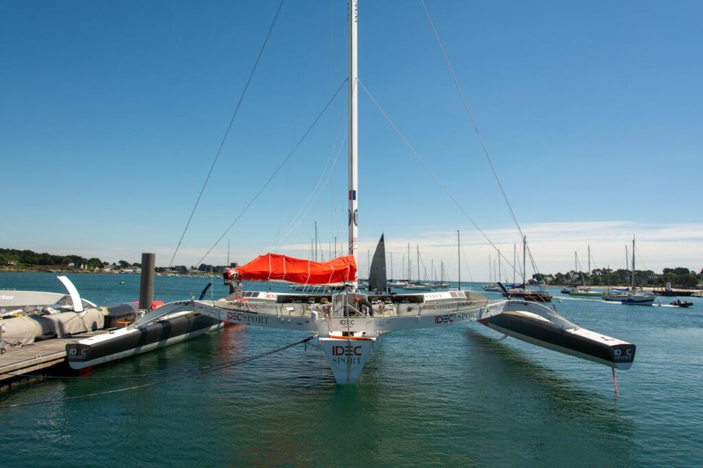 A vibrant trimaran anchored in a serene harbor offers a glimpse into nautical adventures.